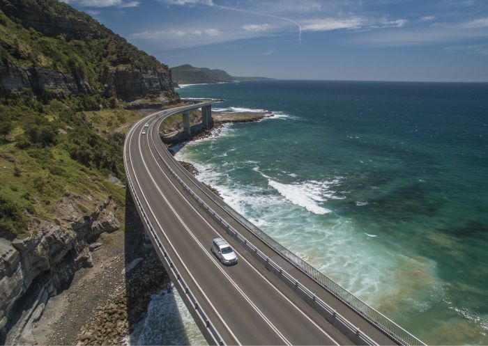 Aerial of a car taking the scenic route over Sea Cliff Bridge in Clifton Sea Cliff Bridge, Clifton