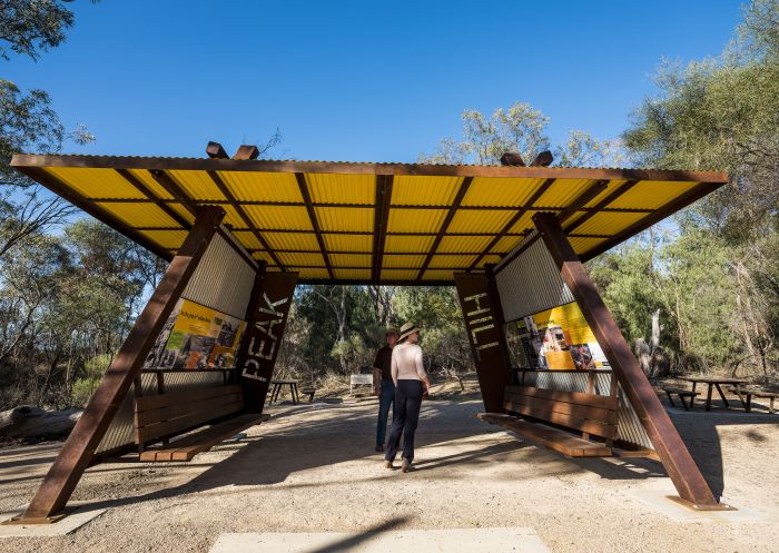 Visitors reading the information signs on a visit to the Peak Hill Open Cut Gold Mine in Parkes Shire