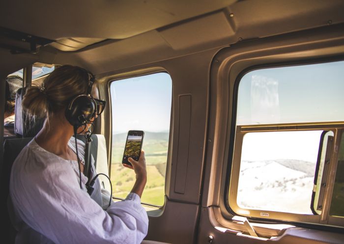 Woman enjoying a scenic flight over Tumut River and the Talbingo Reservoir in the Snowy Mountains