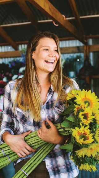 Woman with a bunch of sunflowers at The Farm, Byron Bay
