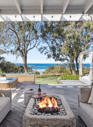Outdoor seating with fire pit and lounge chairs at Barellen Beach House, Coffs Harbour