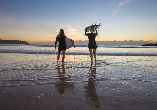 Surfers enjoying the sunset before a morning surf at Diggers Beach, Coffs Harbour